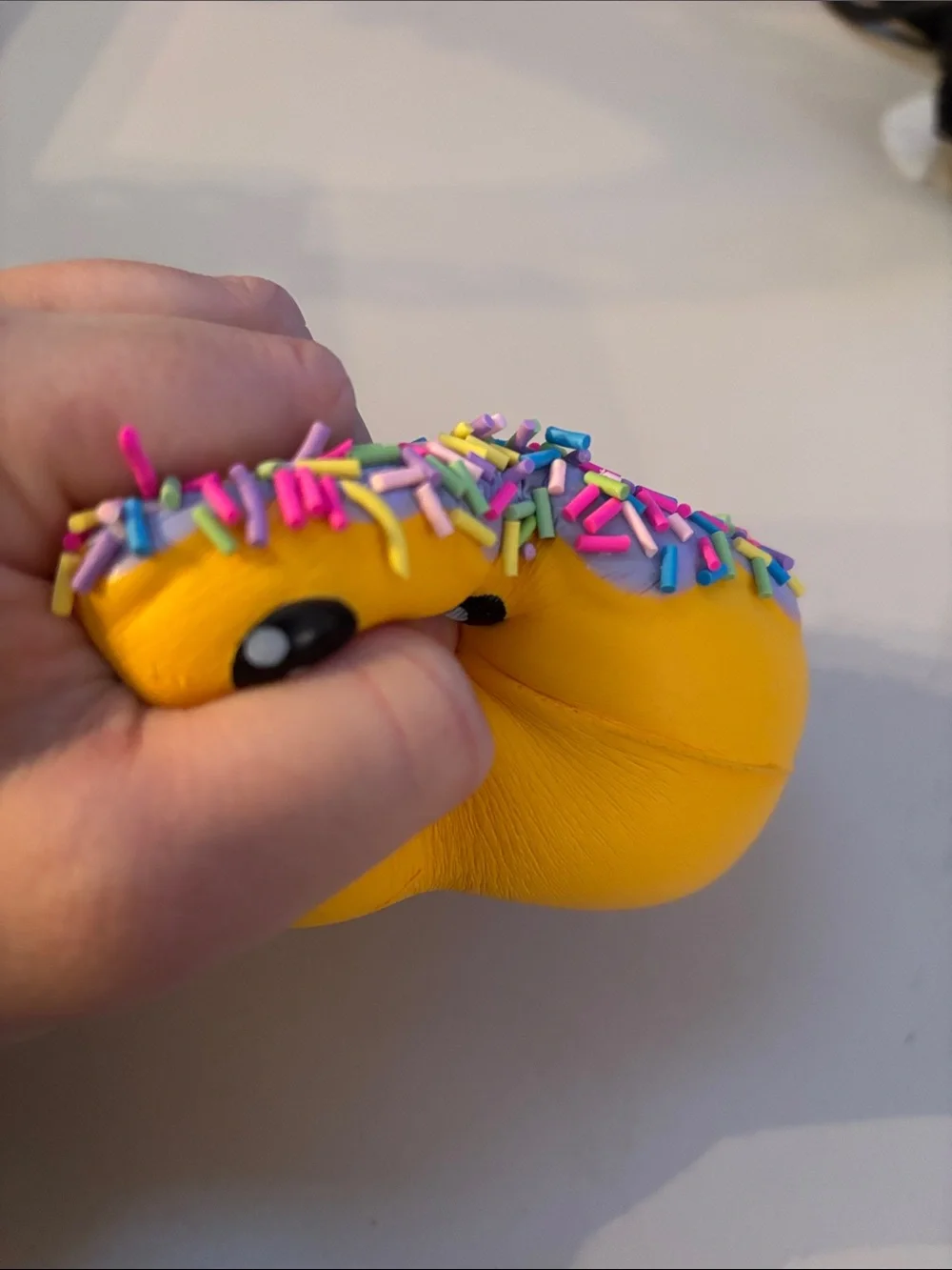 Smiling Yellow Donut Plush Toy with Purple Frosting and Rainbow Sprinkles